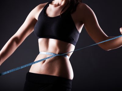 Fitness kvinna våt mage efter träning mäta hennes midja, viktminskning koncept