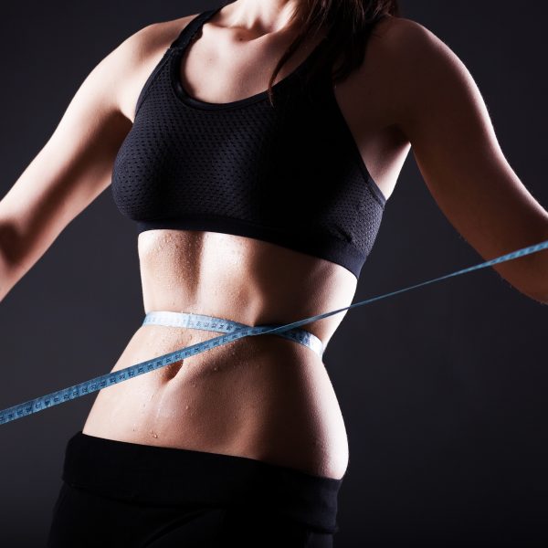 Fitness Frau nassen Bauch nach dem Training Messung ihrer Taille, Gewichtsverlust Konzept