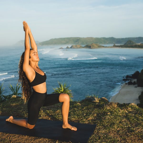 kvinna-utövar-yoga-utomhus-med-fantastiskt-hav